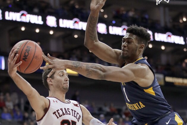 Texas Tech's Davide Moretti (25) passes the ball past West Virginia's Derek Culver (1) during the first half of an NCAA college basketball game in the Big 12 men's tournament Thursday, March 14, 2019, in Kansas City, Mo. (AP Photo/Charlie Riedel)