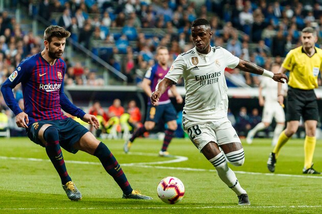 MADRID, SPAIN - MARCH 02: Vinicius Jr. of Real Madrid and Gerard Pique of Barcelona battle for the ball during the La Liga match between Real Madrid CF and FC Barcelona at Estadio Santiago Bernabeu on March 2, 2019 in Madrid, Spain. (Photo by TF-Images/Getty Images)