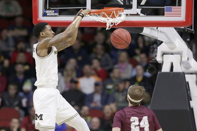 Michigan's Charles Matthews, left, dunks over Montana's Bobby Moorehead (24) during the first half of a first round men's college basketball game in the NCAA Tournament in Des Moines, Iowa, Thursday, March 21, 2019. (AP Photo/Nati Harnik)