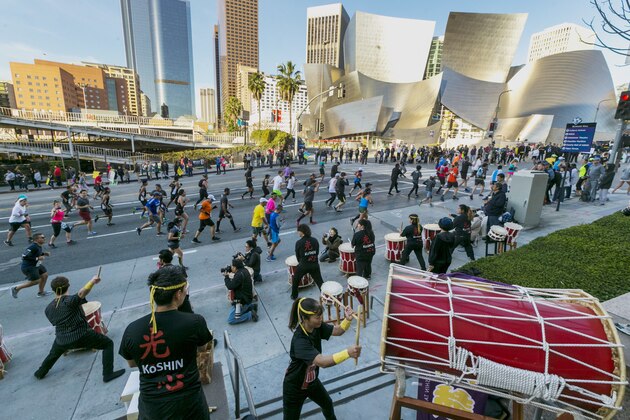 Members of the Venice Koshin Taiko drumming ensemble perform for Los Angeles Marathon runners as they race past the Walt Disney Concert Hall in Los Angeles Sunday, March 18, 2018. (AP Photo/Damian Dovarganes)
