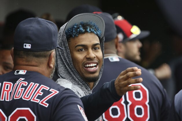 An injured Cleveland Indians' Francisco Lindor talks to a teammate in the dugout during the fourth inning of a spring training baseball game against the Cincinnati Reds Monday, March 11, 2019, in Goodyear, Ariz. (AP Photo/Ross D. Franklin)