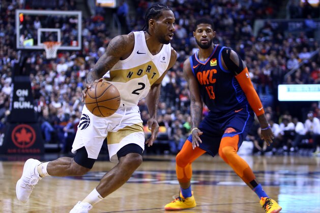 TORONTO, ON - MARCH 22:  Kawhi Leonard #2 of the Toronto Raptors dribbles the ball as Paul George #13 of the Oklahoma City Thunder defends during the second half of an NBA game at Scotiabank Arena on March 22, 2019 in Toronto, Canada.  NOTE TO USER: User expressly acknowledges and agrees that, by downloading and or using this photograph, User is consenting to the terms and conditions of the Getty Images License Agreement.  (Photo by Vaughn Ridley/Getty Images)