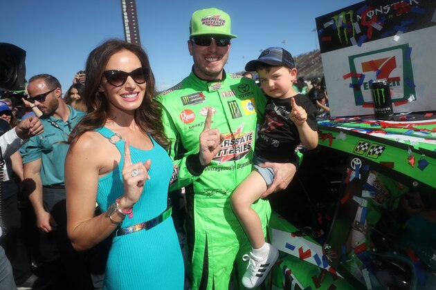 FONTANA, CA - MARCH 17:  Kyle Busch, driver of the #18 Interstate Batteries Toyota, celebrates by placing the Winner's Sticker on his car with his wife Samantha and son Brexton after winning the Monster Energy NASCAR Cup Series Auto Club 400 and winning his 200th NASCAR race at Auto Club Speedway on March 17, 2019 in Fontana, California.  (Photo by Chris Graythen/Getty Images)