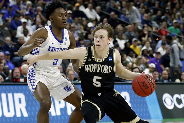 Wofford's Storm Murphy, right, makes a move to get past Kentucky's Immanuel Quickley during the first half of the second round of a men's college basketball game in the NCAA Tournament in Jacksonville, Fla., Saturday, March 23, 2019. (AP Photo/Stephen B. Morton)