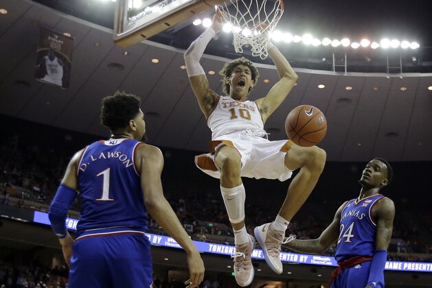 Texas forward Jaxson Hayes (10) celebrates as he scores over Kansas forward Dedric Lawson (1) and guard Lagerald Vick (24) during the second half on an NCAA college basketball game in Austin, Texas, Tuesday, Jan. 29, 2019. Texas won 73-63. (AP Photo/Eric Gay)