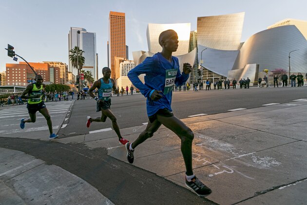 Los Angeles Marathon Elite runners, from left, Weldon Kirui, Simon Njoroge, Elisha Barno race past the Walt Disney Concert Hall in Los Angeles Sunday, March 18, 2018. Kirui won the Los Angeles Marathon with an unofficial time of 2 hours 11 minutes and 47 seconds. (AP Photo/Damian Dovarganes)