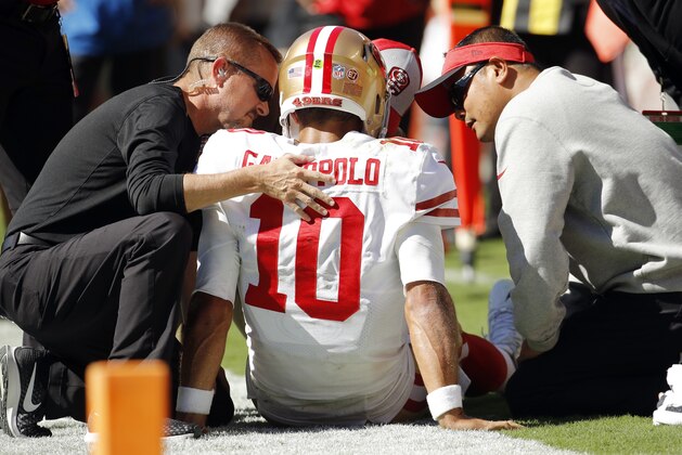El quarterback Jimmy Garoppolo (10), de los 49ers de San Francisco, recibe atención del personal medico del equipo tras sufrir una lesión en el duelo ante los Chiefs de Kansas City, el domingo 23 de septiembre de 2018, en Kansas City, Missouri. (AP Foto/Charlie Riedel)