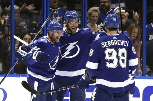 Tampa Bay Lightning center Steven Stamkos (91) celebrates his goal against the Boston Bruins with defenseman Victor Hedman (77) and defenseman Mikhail Sergachev (98) during the first period of an NHL hockey game Monday, March 25, 2019, in Tampa, Fla. (AP Photo/Chris O'Meara)