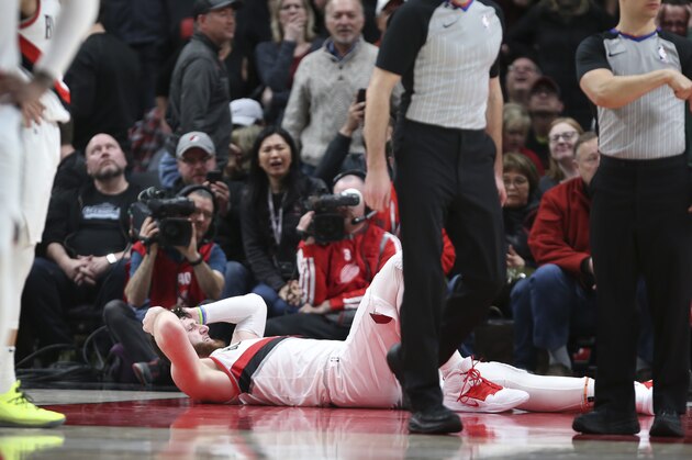 Portland Trail Blazers center Jusuf Nurkic, on ground, was injured and left the court on a stretcher as the Blazers beat the Brooklyn Nets in double overtime, 148-144, during an NBA basketball game in Portland, Ore., Monday, March 25, 2019. (AP Photo/Randy L. Rasmussen)