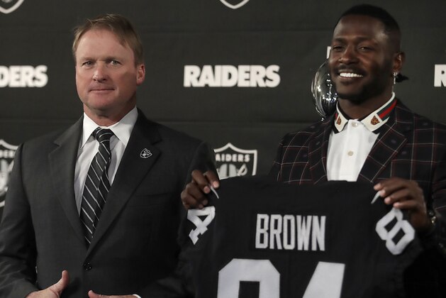 Oakland Raiders wide receiver Antonio Brown, right, holds his jersey beside coach Jon Gruden during an NFL football news conference, Wednesday, March 13, 2019, in Alameda, Calif. (AP Photo/Ben Margot)