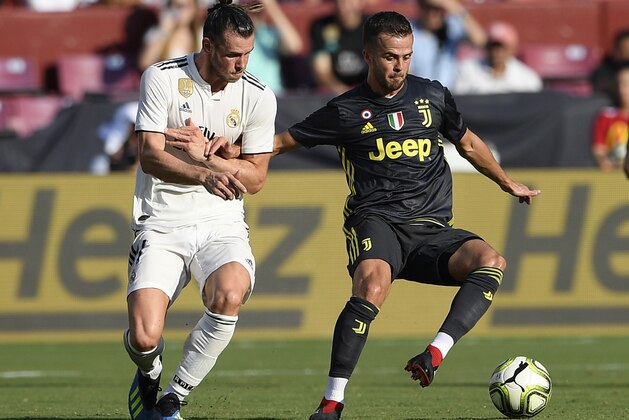 Real Madrid forward Gareth Bale, left, battles for the ball against Juventus midfielder Miralem Pjanic (5) during the first half at an International Champions Cup tournament soccer match, Saturday, Aug. 4, 2018, in Landover, Md. (AP Photo/Nick Wass)