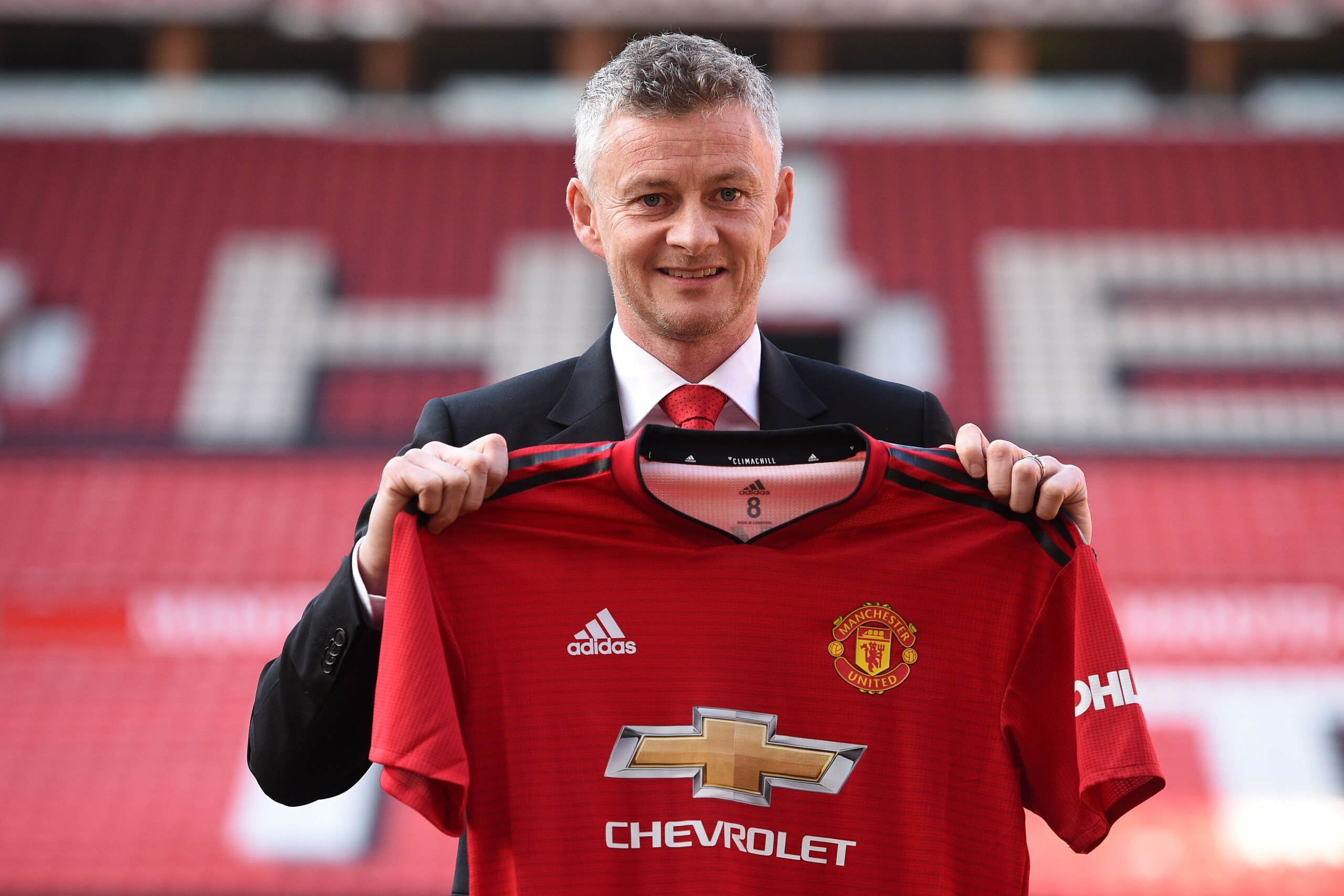 Manchester United's Norwegian manager Ole Gunnar Solskjaer poses with a team jersey during a photo call at Old Trafford in Manchester, northwest England, on March 28, 2019 after it was announced that he was appointed as the clubs full-time manager on a three-year contract. - Ole Gunnar Solskjaer said he was 'beyond excited' to be handed the Manchester United manager's job on a full-time basis as the club announced on Thursday he had signed a three-year deal. (Photo by Oli SCARFF / AFP) / RESTRICTED TO EDITORIAL USE. No use with unauthorized audio, video, data, fixture lists, club/league logos or 'live' services. Online in-match use limited to 75 images, no video emulation. No use in betting, games or single club/league/player publications. /         (Photo credit should read OLI SCARFF/AFP/Getty Images)