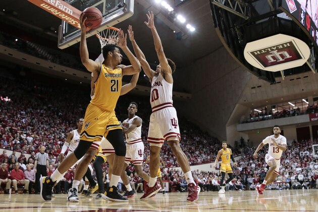 Wichita State forward Jaime Echenique (21) looks to pass over Indiana guard Rob Phinisee (10) in the first half of an NCAA college basketball game in the third round of the NIT tournament, in Bloomington, Ind., Tuesday, March 26, 2019. Wichita State won 73-63. (AP Photo/AJ Mast)