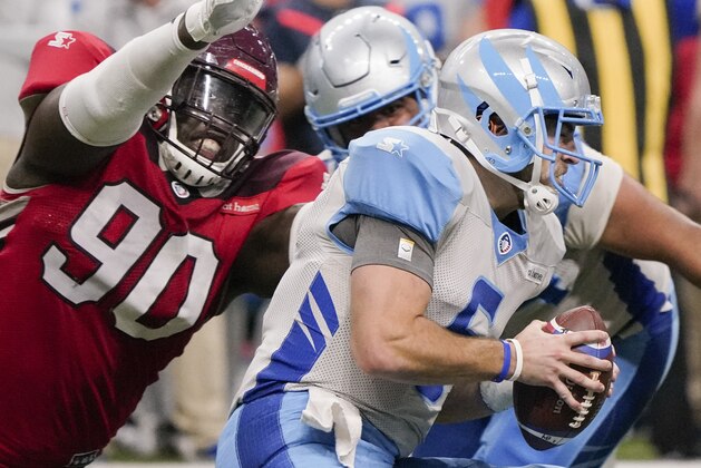 Salt Lake Stallions quarterback Josh Woodrum, right, is tackled by San Antonio Commanders' Joey Mbu during an AAF football game, Saturday, March 23, 2019, at the Alamodome in San Antonio. San Antonio won 19-15. (AP Photo/Darren Abate)