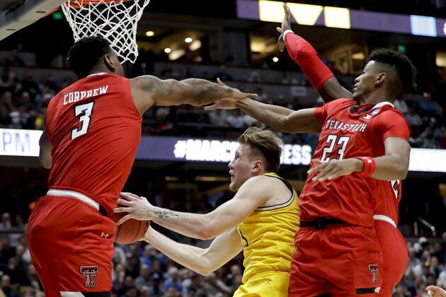 Michigan forward Ignas Brazdeikis, middle, drives to the basket between Texas Tech forward Deshawn Corprew, let, and guard Jarrett Culver during the first half an NCAA men's college basketball tournament West Region semifinal Thursday, March 28, 2019, in Anaheim, Calif. (AP Photo/Marcio Jose Sanchez)