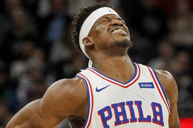 Philadelphia 76ers forward Jimmy Butler grabs his back and grimaces in the first quarter of an NBA basketball game against the Minnesota Timberwolves Saturday, March 30, 2019, in Minneapolis. (AP Photo/Bruce Kluckhohn)