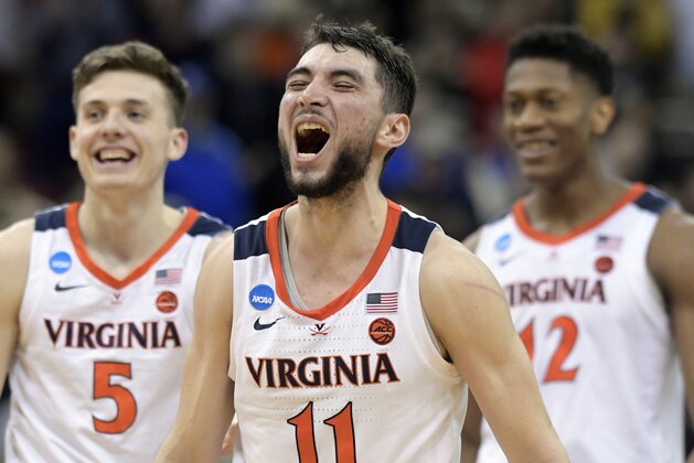 Virginia's Ty Jerome (11) celebrates with teammates Kyle Guy (5) and De'Andre Hunter (12) during overtime of the men's NCAA Tournament college basketball South Regional final game against Purdue, Saturday, March 30, 2019, in Louisville, Ky. Virginia won 80-75. (AP Photo/Timothy D. Easley)