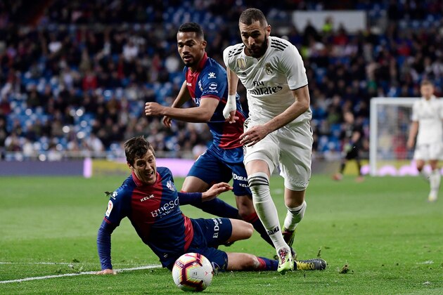 Real Madrid's French forward Karim Benzema (R) challenges SD Huesca's Venezuelan midfielder Yangel Herrera (C) and SD Huesca's Argentinian defender Martin Mantovani (L) during the Spanish League football match between Real Madrid CF and SD Huesca at the Santiago Bernabeu stadium in Madrid on March 31, 2019. (Photo by JAVIER SORIANO / AFP)        (Photo credit should read JAVIER SORIANO/AFP/Getty Images)