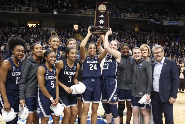 Connecticut players and Connecticut head coach Geno Auriemma, far right, celebrate with their trophy after winning the regional championship game in the NCAA women's college basketball tournament, Sunday, March 31, 2019, in Albany, N.Y. UConn defeated Louisville 80-73 to advance to the Final Four. (AP Photo/Kathy Willens)