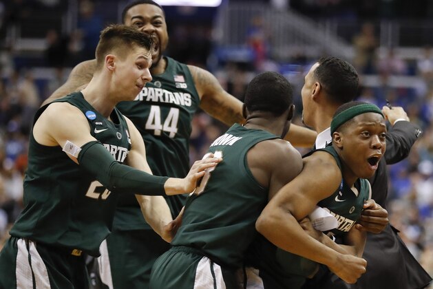 Michigan State guard Cassius Winston, right, celebrates with teammates Matt McQuaid (20), Nick Ward (44) and Gabe Brown (13) after defeating Duke in an NCAA men's East Regional final college basketball game in Washington, Sunday, March 31, 2019. (AP Photo/Patrick Semansky)