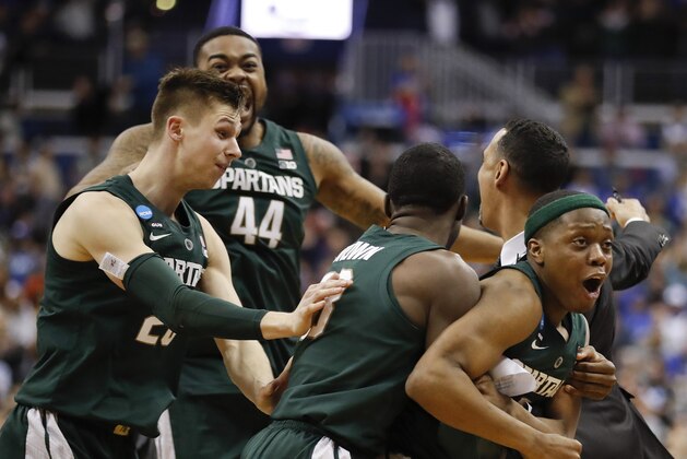Michigan State guard Cassius Winston, right, celebrates with teammates Matt McQuaid (20), Nick Ward (44) and Gabe Brown (13) after defeating Duke in an NCAA men's East Regional final college basketball game in Washington, Sunday, March 31, 2019. (AP Photo/Patrick Semansky)