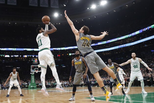 Boston Celtics' Kyrie Irving shoots over Indiana Pacers' Bojan Bogdanovic during the first quarter of an NBA basketball game Friday, March 29, 2019, in Boston. (AP Photo/Winslow Townson)