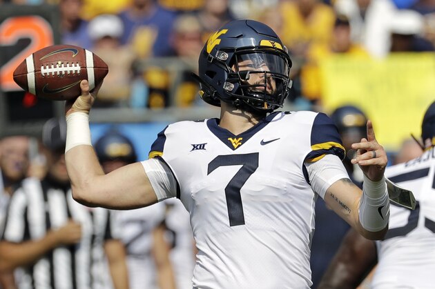 FILE - In this Sept. 1, 2018, file photo, West Virginia's Will Grier (7) looks to pass against Tennessee in the first half of an NCAA college football game, in Charlotte, N.C. Grier is married with a young daughter. (AP Photo/Chuck Burton, File)