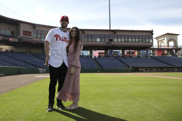 Bryce Harper, left, poses for a photo with his wife Kayla after being introduced as a Philadelphia Phillies player during a news conference at the Philadelphia Phillies spring training baseball facility, Saturday, March 2, 2019, in Clearwater, Fla. Harper and the Phillies agreed to a $330 million, 13-year contract, the largest deal in baseball history. (AP Photo/Lynne Sladky)
