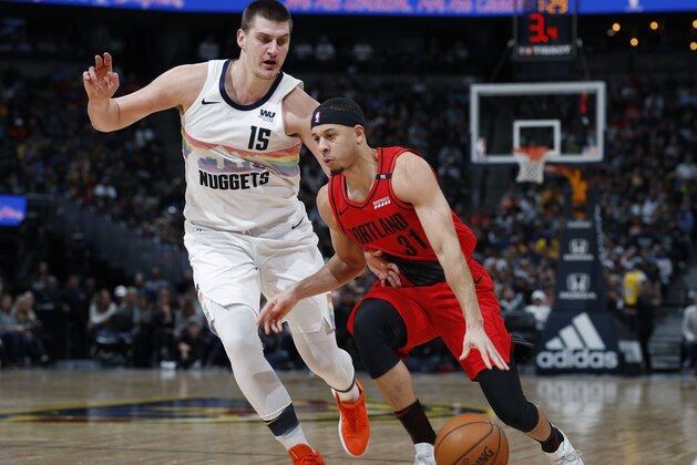 Portland Trail Blazers guard Seth Curry, front, drives to the rim past Denver Nuggets center Nikola Jokic in the second half of an NBA basketball game Sunday, Jan. 13, 2019, in Denver. The Nuggets won 116-113. (AP Photo/David Zalubowski)