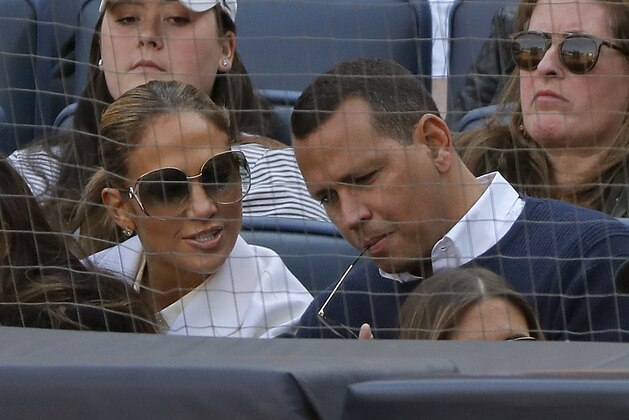 Actress Jennifer Lopez, left, and former major league baseball player Alex Rodriguez watch a baseball game between the New York Yankees and the Baltimore Orioles, Saturday, March 30, 2019, in New York. (AP Photo/Julie Jacobson)