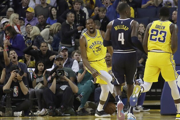 Golden State Warriors forward Kevin Durant (35) reacts after dunking against the Denver Nuggets during the first half of an NBA basketball game in Oakland, Calif., Tuesday, April 2, 2019. (AP Photo/Jeff Chiu)