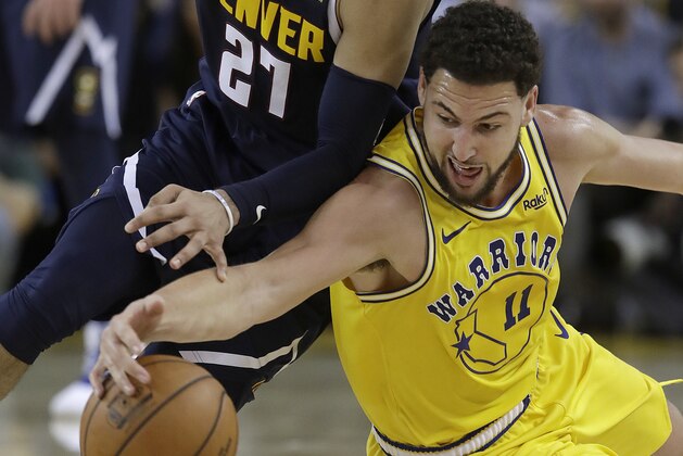 Golden State Warriors guard Klay Thompson, right, reaches for a loose ball under Denver Nuggets guard Jamal Murray (27) during the second half of an NBA basketball game in Oakland, Calif., Tuesday, April 2, 2019. (AP Photo/Jeff Chiu)