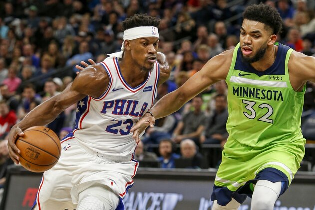 Philadelphia 76ers forward Jimmy Butler (23) drives to the basket around Minnesota Timberwolves center Karl-Anthony Towns (32) in the third quarter of an NBA basketball game Saturday, March 30, 2019, in Minneapolis. (AP Photo/Bruce Kluckhohn)