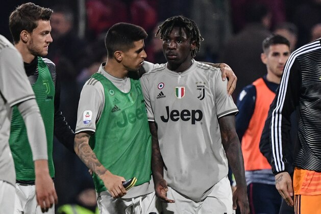 Juventus' Portuguese defender Joao Cancelo (C-L) comforts Juventus' Italian forward Moise Kean at the end of the Italian Serie A football march Cagliari vs Juventus on April 2, 2019 at the Sardignia Arena in Cagliari, after Cagliari's fans threw projectiles at him following his goal. (Photo by Marco BERTORELLO / AFP)        (Photo credit should read MARCO BERTORELLO/AFP/Getty Images)