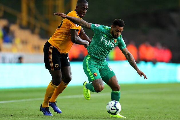 WOLVERHAMPTON, ENGLAND - OCTOBER 20:  Andre Gray of Watford is challenged by Willy Boly of Wolverhampton Wanderers during the Premier League match between Wolverhampton Wanderers and Watford FC at Molineux on October 20, 2018 in Wolverhampton, United Kingdom.  (Photo by Richard Heathcote/Getty Images)