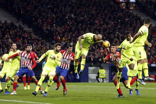 Barcelona's Arturo Vidal center jumps for the ball leaving his arm in the way during a Spanish La Liga soccer match between Atletico Madrid and FC Barcelona at the Metropolitano stadium in Madrid, Saturday, Nov. 24, 2018. (AP Photo/Paul White)