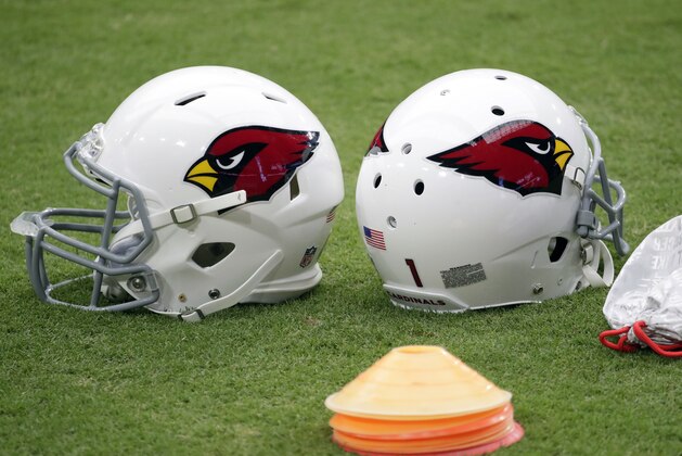 A pair of Arizona Cardinals helmets sit on the field during the first day of their NFL football training camp, Saturday, July 28, 2018, in Glendale, Ariz. (AP Photo/Matt York)