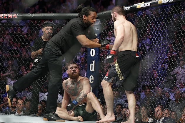 Khabib Nurmagomedov, right, is held back by referee Herb Dean after fighting Conor McGregor, bottom, during a lightweight title mixed martial arts bout at UFC 229 in Las Vegas, Saturday, Oct. 6, 2018. Nurmagomedov won the fight by submission during the fourth round to retain the title. (AP Photo/John Locher)