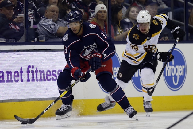 Columbus Blue Jackets defenseman Seth Jones, left, controls the puck against Boston Bruins forward David Pastrnak, of the Czech Republic, during an NHL hockey game in Columbus, Ohio, Tuesday, April 2, 2019. The Bruins won 6-2. (AP Photo/Paul Vernon)