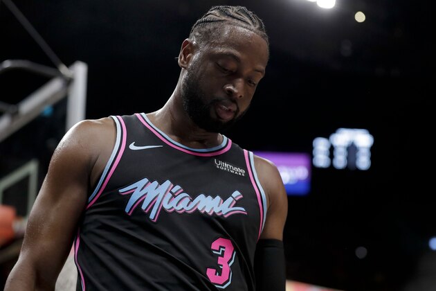 Miami Heat guard Dwyane Wade (3) reacts after he shoots against Phoenix Suns guard Jamal Crawford (11) and Phoenix Suns forward Mikal Bridges (25) during the second half of an NBA basketball game on Monday, Feb. 25, 2019, in Miami, Fla. (AP Photo/Brynn Anderson)
