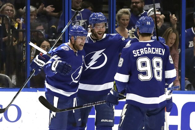 Tampa Bay Lightning center Steven Stamkos (91) celebrates his goal against the Boston Bruins with defenseman Victor Hedman (77) and defenseman Mikhail Sergachev (98) during the first period of an NHL hockey game Monday, March 25, 2019, in Tampa, Fla. (AP Photo/Chris O'Meara)