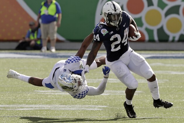 Kentucky safety Davonte Robinson, left, stops Penn State running back Miles Sanders (24) after a short gain during the first half of the Citrus Bowl NCAA college football game, Tuesday, Jan. 1, 2019, in Orlando, Fla. (AP Photo/John Raoux)
