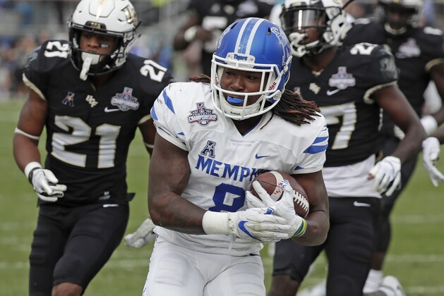 Memphis running back Darrell Henderson, center, runs past Central Florida defensive backs Rashard Causey (21) and  Richie Grant, right, for a 12-yard touchdown run during the first half of the American Athletic Conference championship NCAA college football game, Saturday, Dec. 1, 2018, in Orlando, Fla. (AP Photo/John Raoux)