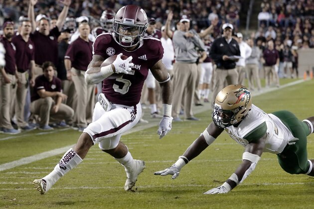Texas A&M running back Trayveon Williams (5) dodges the tackle attempt by UAB linebacker Chris Woolbright, right, to score during the first half of an NCAA college football game Saturday, Nov. 17, 2018, in College Station, Texas. (AP Photo/Michael Wyke)