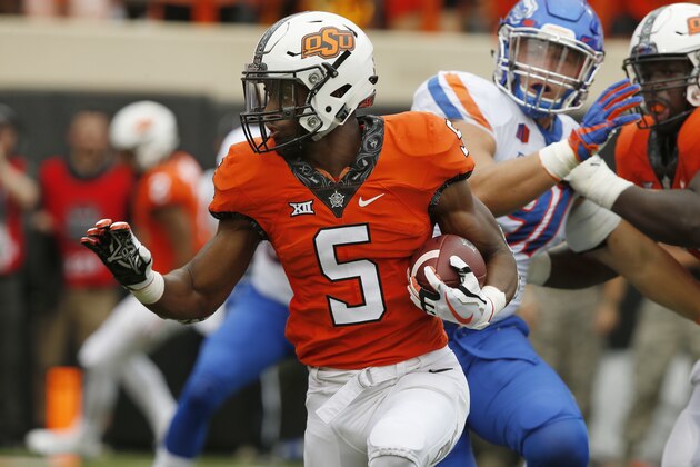 Oklahoma State running back Justice Hill (5) runs past Boise State defensive end Durrant Miles, center, and teammate Marcus Keyes (75) and into the endzone with a touchdown in the first half of an NCAA college football game in Stillwater, Okla., Saturday, Sept. 15, 2018. (AP Photo/Sue Ogrocki)