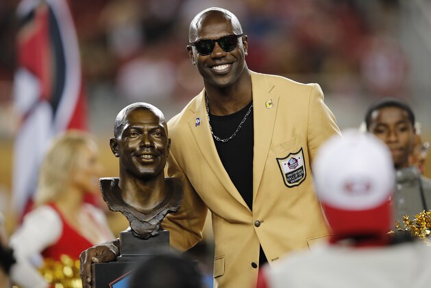 Former NFL wide receiver Terrell Owens poses next to his Pro Football Hall of Fame bust during halftime of an NFL football game between the San Francisco 49ers and the Oakland Raiders in Santa Clara, Calif., Thursday, Nov. 1, 2018. (AP Photo/John Hefti)