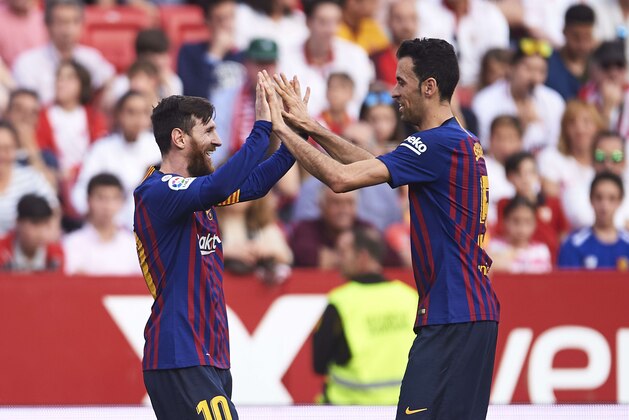 SEVILLE, SPAIN - FEBRUARY 23: Lionel Messi of FC Barcelona celebrates with his teammates Sergio Busquets of FC Barcelona after scoring his team's third goal during the La Liga match between Sevilla FC and FC Barcelona at Estadio Ramon Sanchez Pizjuan on February 23, 2019 in Seville, Spain. (Photo by Aitor Alcalde/Getty Images)