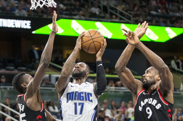 Orlando Magic forward Jonathon Simmons (17) takes the ball up on Toronto Raptors forward Chris Boucher (25) and forward Serge Ibaka (9) during the second half of an NBA basketball game in Orlando, Fla., Friday, Dec. 28, 2018. (AP Photo/Willie J. Allen Jr.)