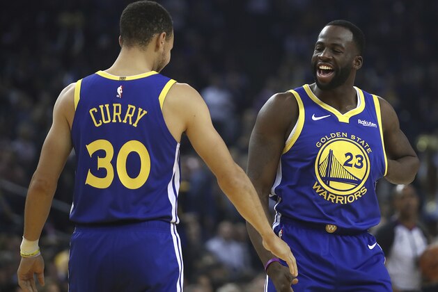 Golden State Warriors' Draymond Green, right, greets Stephen Curry (30) prior to the first half of an NBA basketball game against the Minnesota Timberwolves Monday, Dec. 10, 2018, in Oakland, Calif. The first game both have retuned to play at home since recovering from injuries. (AP Photo/Ben Margot)
