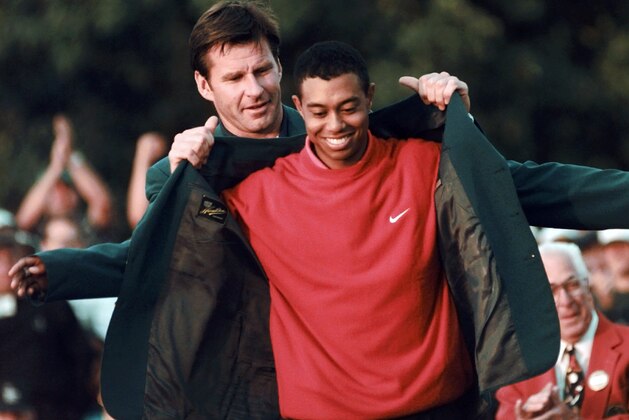 FILE - In this April 13, 1997, file photo, Masters champion Tiger Woods receives his green jacket from the previous year's winner Nick Faldo, rear, at the Augusta National Golf Club in Augusta, Ga. In a statement Tuesday, March 16, 2010, Woods said he will play at Augusta National after a four-month hiatus because of a sex scandal. The Masters begins on April 8. (AP Photo/ Dave Martin, File)
